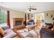 Cozy living room with a brick fireplace, wood floors, and comfortable seating, perfect for relaxation at 285 Aspen Way, Fayetteville, GA 30214