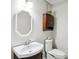 Cozy powder room featuring a pedestal sink, an octagon mirror, and convenient commode at 285 Aspen Way, Fayetteville, GA 30214