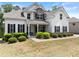 Charming two-story home with stone accents, a covered porch, lush landscaping, and a well-manicured lawn at 2855 Pilgrim Mill, Cumming, GA 30041