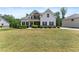 Beautiful home featuring stone accents, a covered porch, lush landscaping, and a well-manicured lawn at 2855 Pilgrim Mill, Cumming, GA 30041