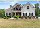 Beautiful home featuring stone accents, a covered porch, lush landscaping, and a well-manicured lawn at 2855 Pilgrim Mill, Cumming, GA 30041