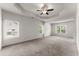 Spacious main bedroom with tray ceiling, ceiling fan and large windows offering natural light at 2855 Pilgrim Mill, Cumming, GA 30041