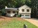 Charming two-story home with a cozy front porch, red shutters, and a two-car garage at 318 Bakers Bridge Cir, Douglasville, GA 30134