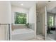 Serene bathroom boasts a soaking tub, a glass-enclosed shower, and a view of the lush outdoors at 3481 Lakeview Crk, Lithonia, GA 30038