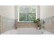 Close up of relaxing soaking tub with bright window and tile surround at 3481 Lakeview Crk, Lithonia, GA 30038