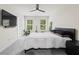 Bright bedroom features plush carpet, ceiling fan, and large windows with a view of lush greenery at 3481 Lakeview Crk, Lithonia, GA 30038