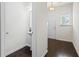 Clean hallway with pedestal sink, mirror, dark wood flooring, and natural lighting at 3481 Lakeview Crk, Lithonia, GA 30038