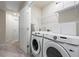 Bright laundry room features modern washer and dryer, shelving and neutral paint at 3481 Lakeview Crk, Lithonia, GA 30038