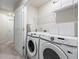 Bright laundry room equipped with modern washer and dryer units and storage shelves for organization at 3481 Lakeview Crk, Lithonia, GA 30038