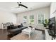 Bright living room with hardwood floors, modern ceiling fan, and natural light at 3481 Lakeview Crk, Lithonia, GA 30038