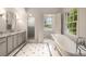 A stylish bathroom boasting marble floors, a shower, and a soaking tub by the window at 3916 E Brookhaven Ne Dr, Brookhaven, GA 30319