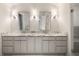 Bright bathroom featuring a marble countertop with dual sinks, decorative light fixtures, and updated cabinets at 3916 E Brookhaven Ne Dr, Brookhaven, GA 30319