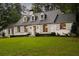 Charming white brick home with arched windows, dormers, shutters, manicured lawn and mature trees at 3916 E Brookhaven Ne Dr, Brookhaven, GA 30319