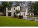 Two-story home exterior with white brick, green grass, and white picket fence at 3916 E Brookhaven Ne Dr, Brookhaven, GA 30319