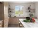 Bright kitchen with marble counters, open shelving, and arched window overlooking the backyard at 3916 E Brookhaven Ne Dr, Brookhaven, GA 30319