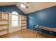 Bedroom featuring built-in shelving, large arched window, textured ceiling fan and blue accent wall at 911 White Stag Ln, Canton, GA 30115