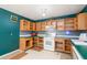 Outdated kitchen with blue walls, unfinished wood cabinets, and older appliances at 911 White Stag Ln, Canton, GA 30115