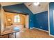 Partially renovated living room featuring blue accent wall and large opening leading to adjacent living space with vaulted ceilings at 911 White Stag Ln, Canton, GA 30115