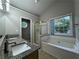 Bright bathroom featuring double sinks, granite countertops, a soaking tub, and a separate shower at 1415 Stoney Field Pl, Lawrenceville, GA 30043