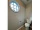 Neutral half bathroom featuring a round accent window, painted walls, and standard toilet at 1415 Stoney Field Pl, Lawrenceville, GA 30043
