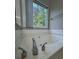 Close up of a soaking tub with tile surround and chrome fixtures, showcasing natural light at 1415 Stoney Field Pl, Lawrenceville, GA 30043