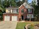 Charming two-story home with a manicured lawn, a brick facade, and a two-car garage at 1415 Stoney Field Pl, Lawrenceville, GA 30043
