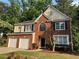 Charming brick and siding two-story home with well-manicured lawn, landscaping, and a two-car garage at 1415 Stoney Field Pl, Lawrenceville, GA 30043