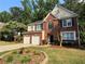 Charming brick and siding two-story home with well-manicured lawn, landscaping, and a two-car garage at 1415 Stoney Field Pl, Lawrenceville, GA 30043