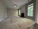 Spacious living room featuring plush carpet flooring, a classic fireplace, and bright windows at 1415 Stoney Field Pl, Lawrenceville, GA 30043