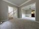 Open concept living room featuring wainscotting, plush carpet flooring, and doors leading to the stairs at 1415 Stoney Field Pl, Lawrenceville, GA 30043