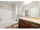 Well-lit bathroom with a tiled shower-tub combo and a vanity with granite countertop at 175 Orchard Ln, Covington, GA 30014