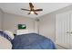 Bedroom with ceiling fan, large window, and an adjacent closet with double doors at 451 Tioram Se Ln, Smyrna, GA 30082