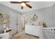 Bright Bedroom with crib, changing table, ceiling fan, and built-in book shelves at 451 Tioram Se Ln, Smyrna, GA 30082