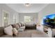 Well-lit living room with a large sectional sofa, a modern TV stand, and a view of the backyard at 451 Tioram Se Ln, Smyrna, GA 30082