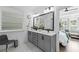 Bright bathroom with gray vanity, double sinks, large mirror, and doorway to bedroom at 518 Hargrove Ln, Decatur, GA 30030