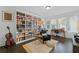 Cozy living room with a floor-to-ceiling bookshelf, hardwood floors, and natural light at 518 Hargrove Ln, Decatur, GA 30030