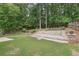 Spacious backyard with a stone patio, tiered landscaping, and mature trees at 9811 Spyglass Dr, Villa Rica, GA 30180