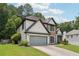 Lovely home featuring a pristine lawn, attached garage, and mature trees offering ample shade and curb appeal at 9811 Spyglass Dr, Villa Rica, GA 30180