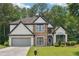 Charming home with a stone and stucco facade, complemented by a well-manicured lawn and lush landscaping at 9811 Spyglass Dr, Villa Rica, GA 30180