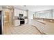 Spacious kitchen with white cabinets, stainless steel appliances, and a breakfast bar overlooking a sunny breakfast nook at 9811 Spyglass Dr, Villa Rica, GA 30180