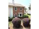 Charming brick two-story townhome featuring a bay window and neatly manicured shrubbery in the front yard at 210 Mill Creek Pl, Roswell, GA 30076