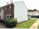 Side view of a two-story townhome, showcasing the neatly maintained lawn and adjacent covered parking area at 210 Mill Creek Pl, Roswell, GA 30076