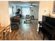 Open-concept living space with hardwood floors, a piano, and a cozy seating area at 210 Mill Creek Pl, Roswell, GA 30076
