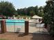 Community pool area featuring lounge chairs, umbrellas, and secure fencing for residents' enjoyment and relaxation at 210 Mill Creek Pl, Roswell, GA 30076