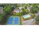 Aerial view showcasing a community pool and tennis courts surrounded by lush greenery at 1304 Swallows Walk, Grayson, GA 30017