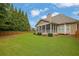 Expansive backyard featuring a screened porch, lush lawn, and mature trees for outdoor enjoyment at 1304 Swallows Walk, Grayson, GA 30017
