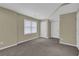 An ample bedroom space with neutral colors, a large window, and two white doors at 1304 Swallows Walk, Grayson, GA 30017