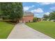 Long driveway leading to a brick home with a convenient garage entrance and well-kept landscaping at 1304 Swallows Walk, Grayson, GA 30017