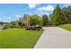 Beautiful brick home featuring a well-manicured lawn, mature trees, and a lengthy concrete driveway at 1304 Swallows Walk, Grayson, GA 30017