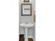 Traditional half-bathroom with pedestal sink, framed mirror, and brass hardware at 1304 Swallows Walk, Grayson, GA 30017